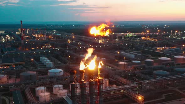 Refinery Flare Stacks are Releasing Flashes of Fire in the Evening alt