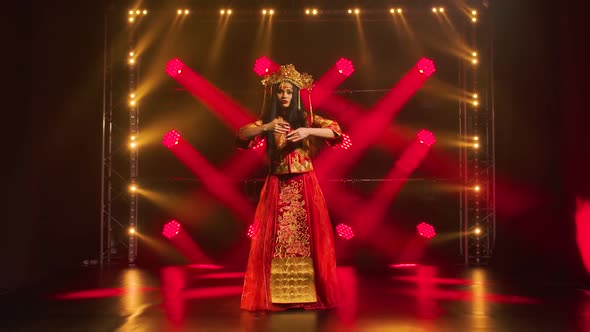 Slender Woman Is Performing a Beautiful Folk Dance. Performance on Stage in the Rays alt