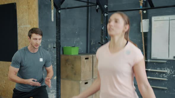 Girl Skipping with Jump Rope While Guy Instructor Clapping Hands Motivating Student alt