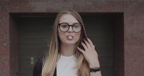 Hipster in Glasses Blows Bubble of Chewing Gum and Has Fun with Bursted It alt