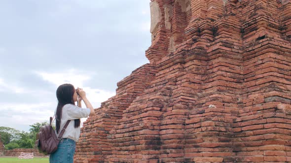 Asian woman using camera for take a picture while spending holiday trip at Ayutthaya.