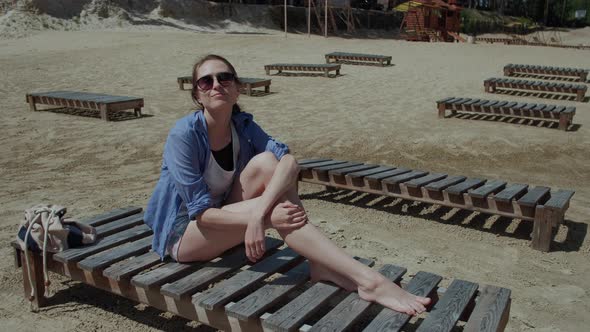 Woman on Vacation Resting on the Beach Lying on a Sun Lounger alt