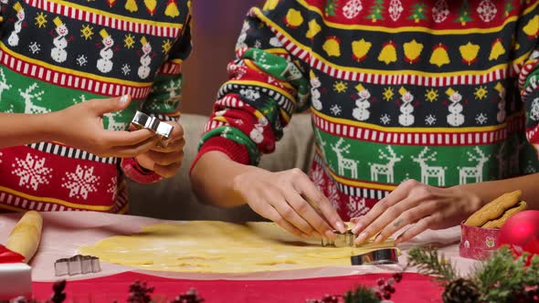 African American Mom and Little Daughter in Bright Holiday Sweaters Cut Festive Homemade Cookies alt