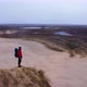 Aerial Of a Tourist Standing on a Top of Sand Dune and Enjoying Panoramic View - VideoHive Item for Sale