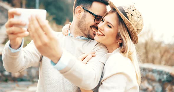 Beautiful Couple Taking Selfies and Smiling While Traveling