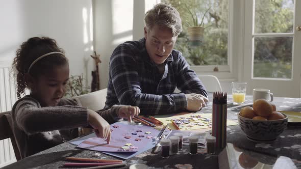 Parents with daughter drawing in living room