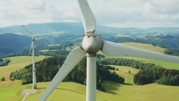 Zoom Out of Camera From a Propeller of the Windmill in the Field with Mountains on the Background alt