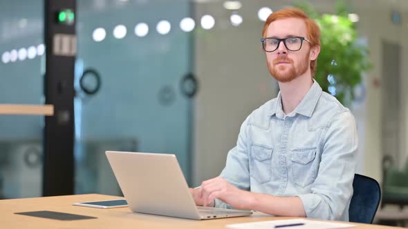 Cheerful Businessman with Laptop Smiling at Camera in Office alt