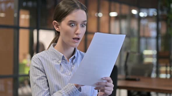 Excited Woman Celebrating After Reading Documents alt