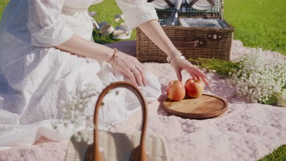 RED Camera Slow Motion Woman Sitting Outside on Grass Eating Fruits on Picnic alt