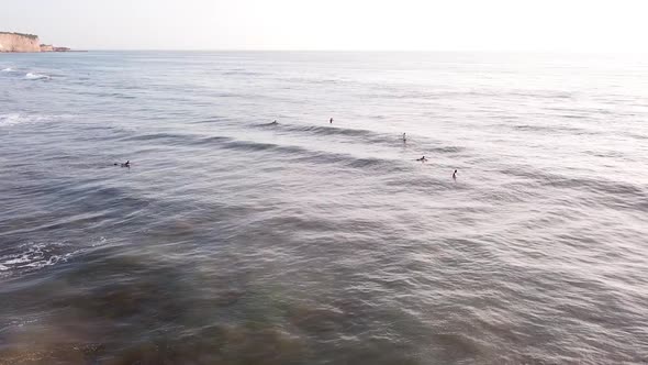 Surfers Surfing At Olon Beach During Golden Hour At Sunset In Summer. - aerial arc shot alt