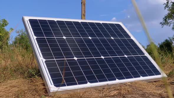 Portable Solar Panel Against Sky and Clouds Lying on the Ground Used in Tourism alt