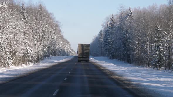 Truck Of Transport Company Driving In Winter On Highway Delivering Cargo alt