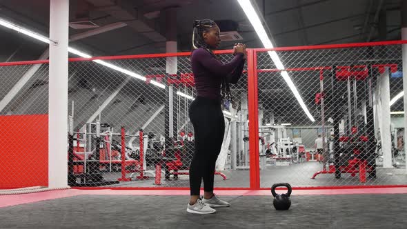 Sports in the Modern Gym  Africanamerican Woman Squatting alt