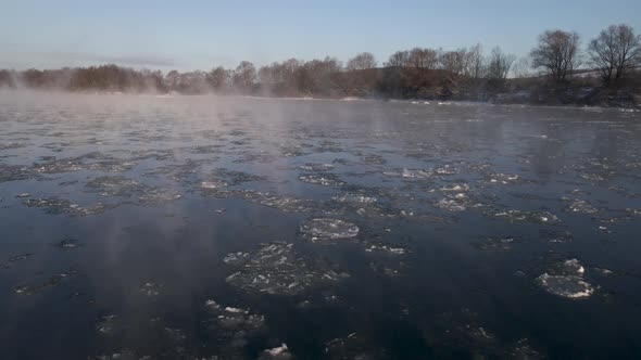 Aerial Drone Close Up View on the Frozen River with Haze and Floating Ice Early Morning