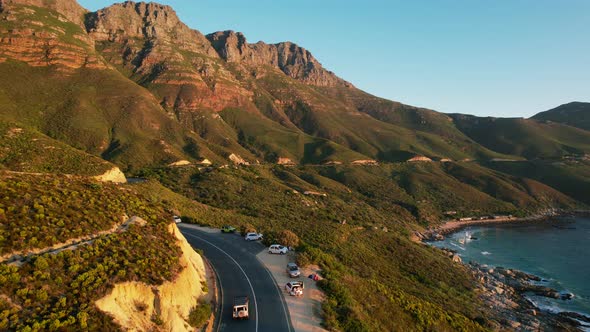 Scenic coastal drive along Chapmans Peak road in Cape Town at sunset, aerial alt