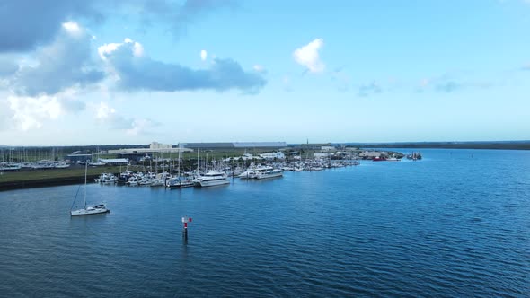 A fast panning drone view of multiple boats docked in a protected harbor located in the town of Barg alt