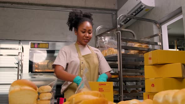 Female cook is packing handmade and fresh-baked bread for online customers.