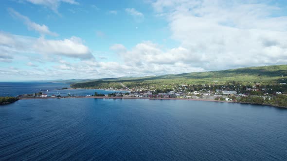 Drone shot over lake superior of Grand Marais on a sunny day in the summer alt