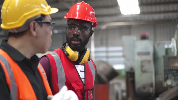 Diversity people in protecting clothing walking and discussing about work at the factory alt