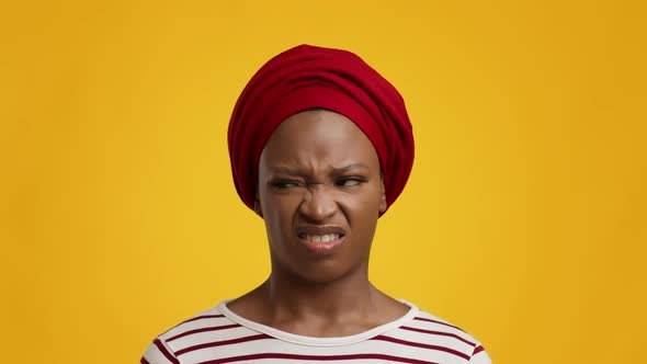 Disgusted African Lady Smelling Unpleasant Stink Wearing Headwrap Yellow Background alt