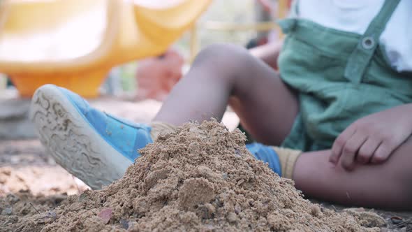 Close-up of black people boy playing sand in playground in park