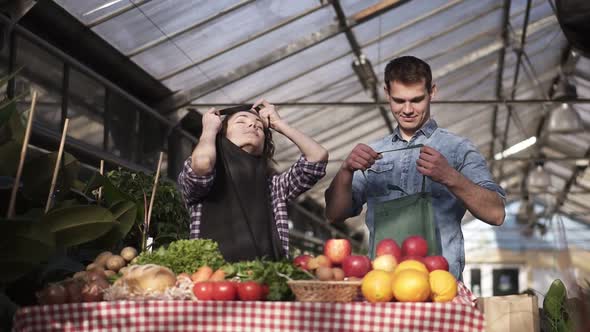 Portrait of Beautiful Caucasian Farmers Man and Woman Putting Aprons and Gloves Selling Organic Food alt