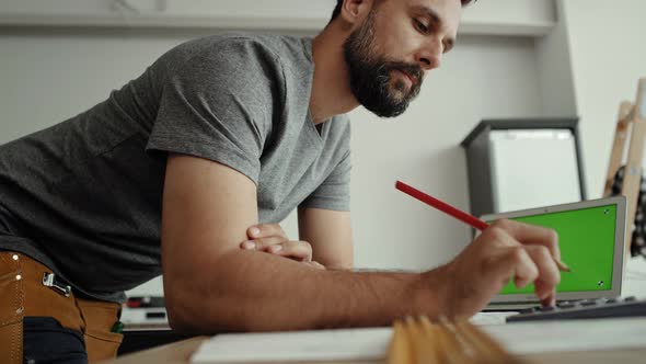 Video of carpenter doing calculations at the computer. Shot with RED helium camera in 8K alt