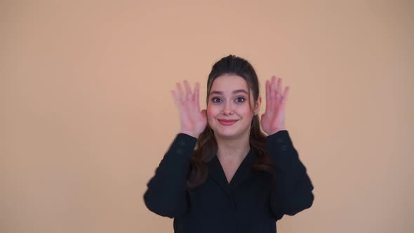 Happy Adorable Woman with Brunette Hair in Black Jacket Opening and Covering Her Face with Hands alt