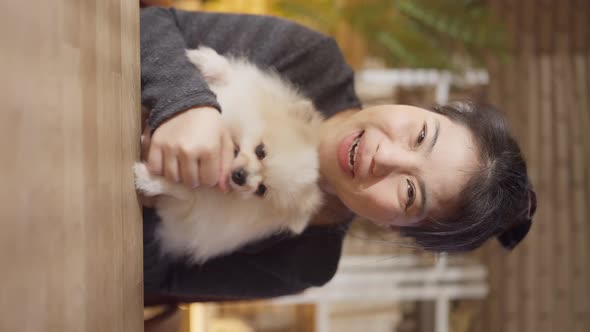 asian woman stay home and working with dog friend together pov vertical shot