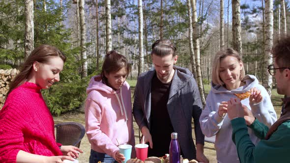 Group of Joyful Young People Enjoying Outdoor Summer Picnic Meal, BBQ Party