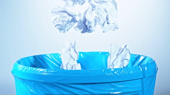 Super Slow Motion Shot of Crumpled Papers Falling Into Bin at 1000Fps alt