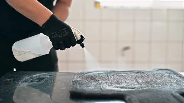 Working cleaner at car wash. Cleaning a carpet using a spray with chemical solution. Slow motion alt