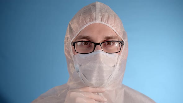 Man in Protective Jumpsuit Removes Medical Mask Hood Sighs Deeply