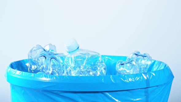 Super Slow Motion Shot of Crumpled Plastic Bottles Falling Into Trash Can at 1000Fps alt