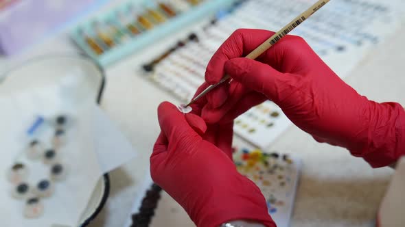 Artificial plastic human eye in doctor's hands. Eyes transplantation. Eye prosthesis. Closeup. alt