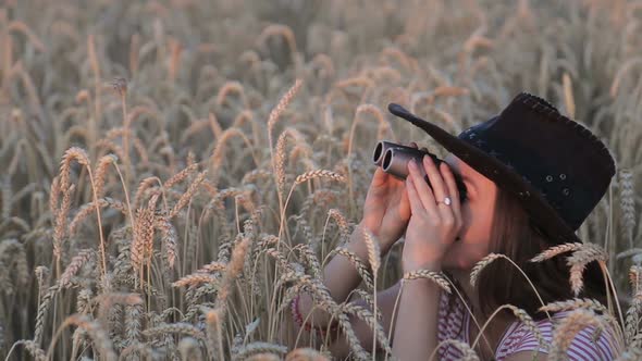 Beautiful Young Girl Looking Through Binoculars On Blue Sky Background. alt