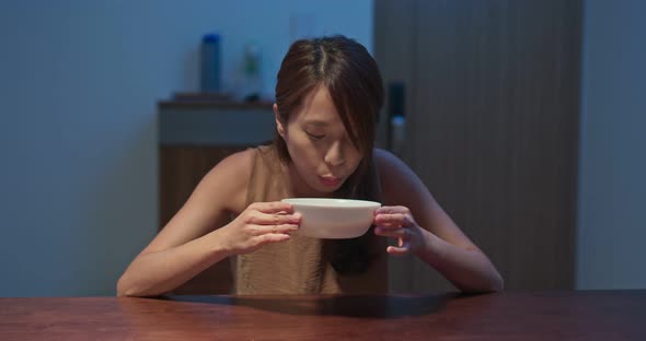 Woman drink of hot soup at home alt
