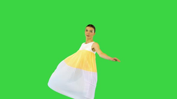 Young Beautiful Girl Turns Holding a Tip of Her Dress on a Green Screen Chroma Key alt