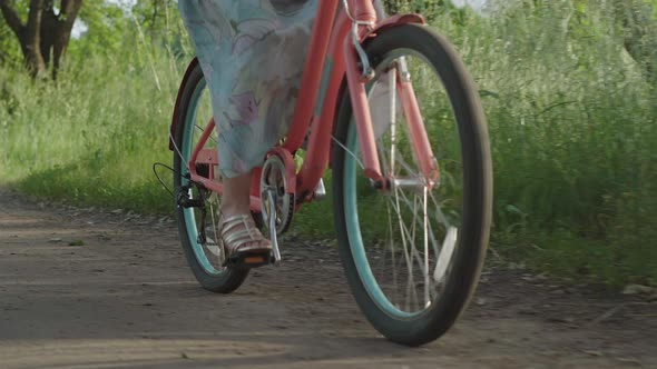 Female Caucasian Feet Pedaling Bike Outdoors on Sunny Summer Day. Unrecognizable Young Woman in High alt