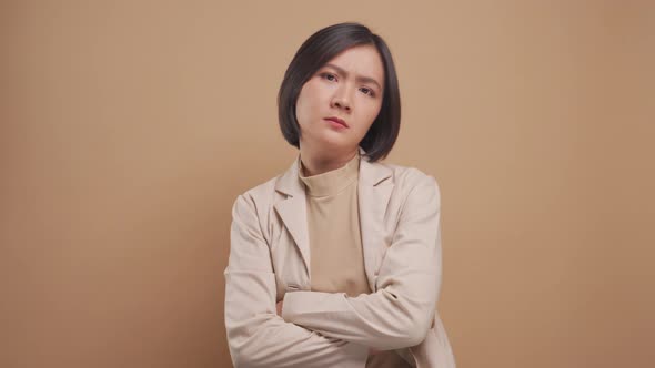 Asian business woman angry and crossed arms looking at camera standing isolated