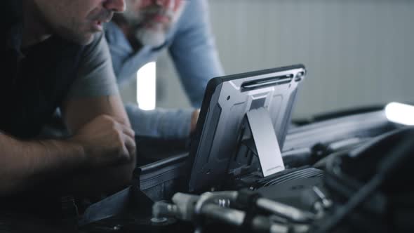 Car Mechanic with Client Using Tablet alt