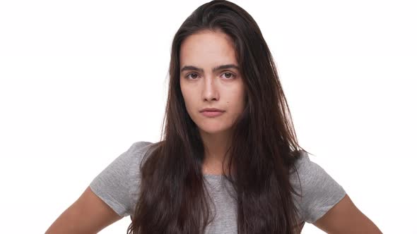 Portrait of Caucasian Young Brunette Woman Being Bored Rolling Her Eyes Isolated Over White alt
