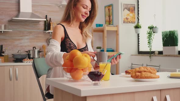 Seductive Housewife in Black Lingerie Using Smartphone alt