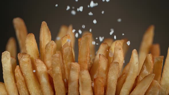 Super Slow Motion Detail Shot of Adding Salt on Fresh French Fries at 1000Fps alt