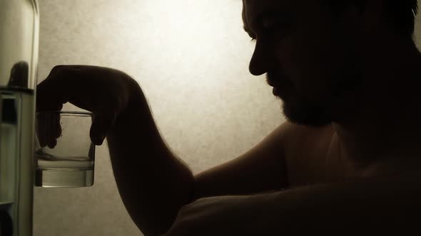 Alcoholic Man Drinking Vodka Sitting at a Table with Bottles Silhouette Video alt