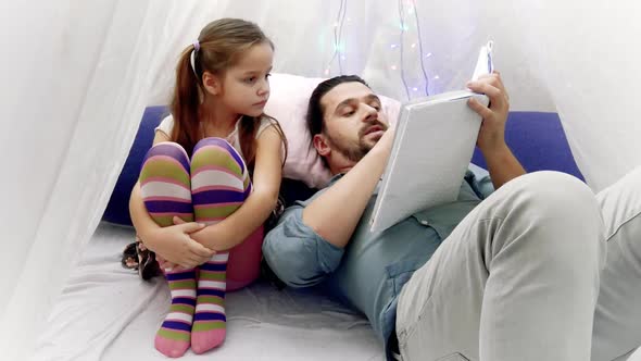 Little Girl and Her Father Reading a Book Together alt