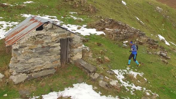 Aerial view of a trail runner and a small house alt