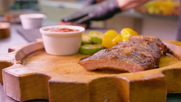 Juicy Grilled Pork Ribs are Served By the Chef on a Decorative Wooden Tray alt