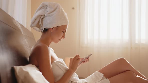 Middleaged Woman Sit Crosslegged on Couch Holds Cellphone Got Good News By Sms alt